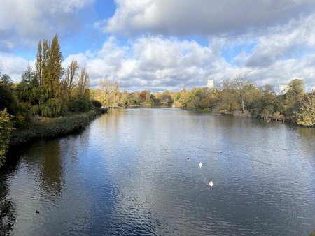 Autumn landscape with lake and blue cloudy sky in Hyde Park