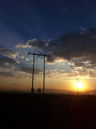 South African sunrise with Power lines. Really cool rays coming from the sun. の素材