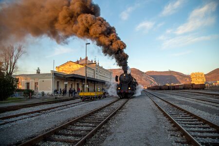 Nova Gorica, Slovenia - December 17, 2017: Old steam train leaving the railway station of  Nova Gorica, Slovenia, lots of black and gray steamのeditorial素材