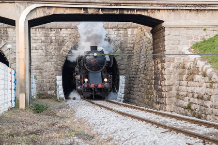 Old steam train leaving the railway station of  Nova Gorica, Slovenia, lots of black and gray steam