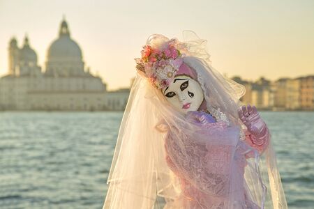 Venice, Italy - February 10, 2015: Single traditional Venetian mask on St. Mark's Square in Venice. Portrait of a woman wearing a mask in Venice during the carnival days.のeditorial素材