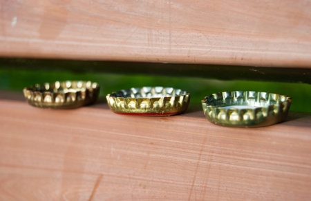 Three stacked bottle caps side by side on a benchの写真素材