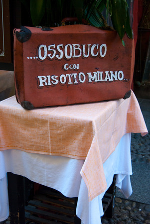 Written Ossobuco with Risotto Milano on suitcase on table - Italyの写真素材