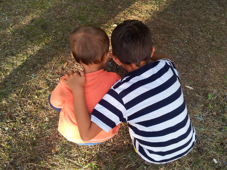 Little explorers watching insects on the groundの写真素材