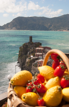 Rough sea and castle with basket of lemons and tomatos  in Vernazza - Italyの写真素材