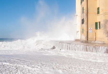 View of pier under a big wave and church wall of Camogliの写真素材