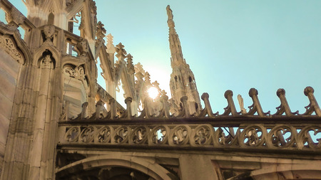Some spiers of the Milan Cathedral with sun and a  blue skyの写真素材