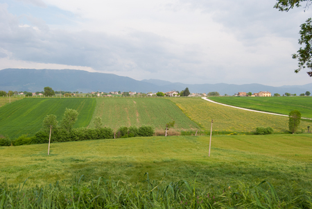 Panorama on hills close to Perugia with processed agricultural fields and white dirt roadの写真素材