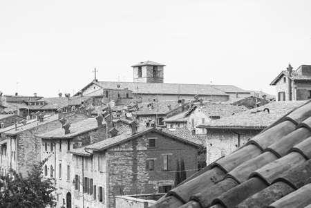 Part of medieval city with storical stones constructions and little church from the top of Gubbioの写真素材