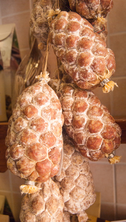 Typical salami called Palle del nonno on the wall outside a grocery storesの写真素材
