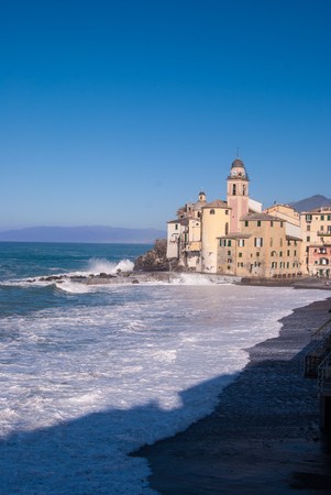 Big waves are breacking in the beach of Camogli with a blue and clear skyの写真素材