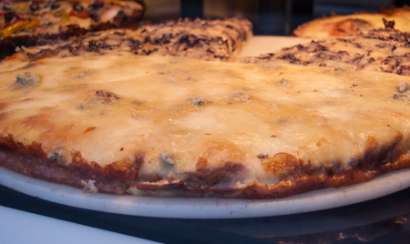 Different tastes of pizza in a bakery window of Milanの写真素材