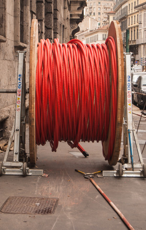 View of a big coil on sidewalk in a working areaの写真素材