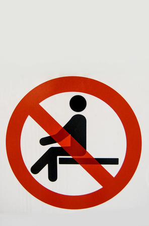 Signal with the red circle and a stylized man indicating that it is not possible to sit downの写真素材