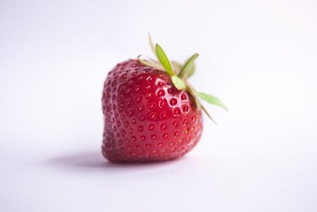 Close up of one strawberry ready to eat on white backgroundの写真素材