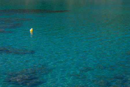One yellow buoy for anchoring boats in the middle of the seaの写真素材