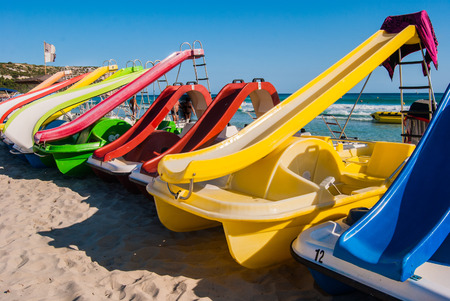 Pedalos on the sandy shoreline of the  Menorca beachの写真素材