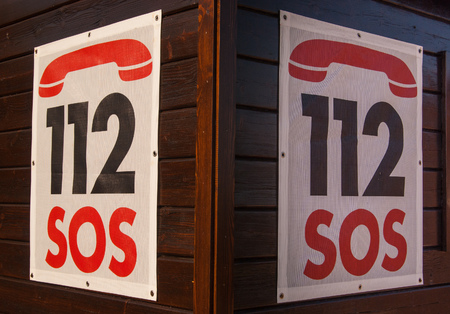 Two SOS numbers hung on the first aid stationの写真素材