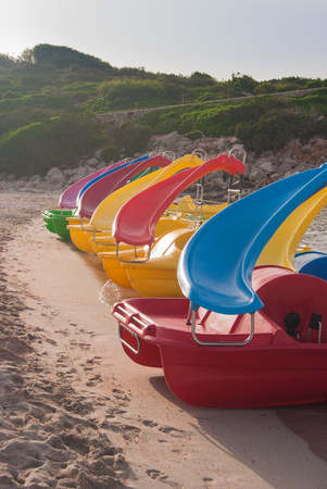 Pedalos on the sandy shoreline of the  Menorca beachの写真素材