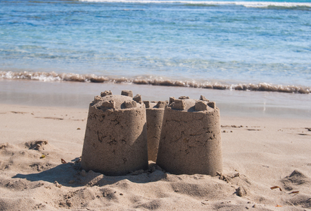Castle of sand with three towers by the seaの写真素材