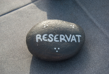 Word reservation handwritten on a stone placed on a table in a restaurantの写真素材