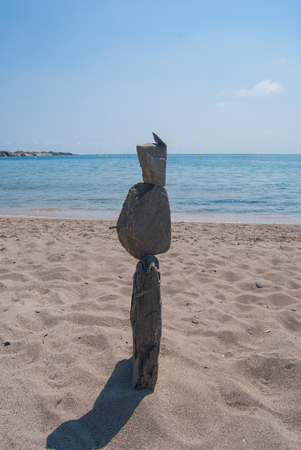 Pyramid of stones on the beach and leaden skyの写真素材