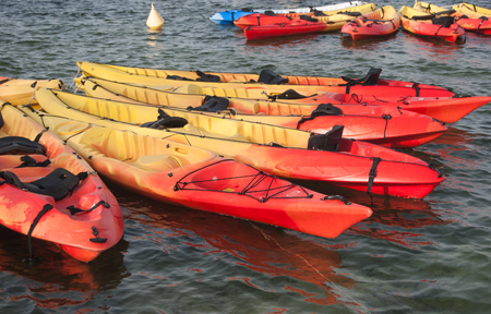 Yellow and red canoe tied together with a buoy in the seaの写真素材