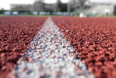 Single white line on the red carpet of the athletics ringの写真素材