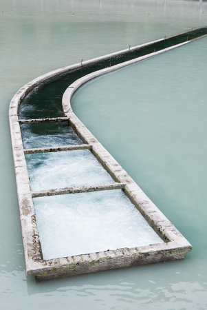 Long watercourse with filtered and tumultuous water in a damの写真素材