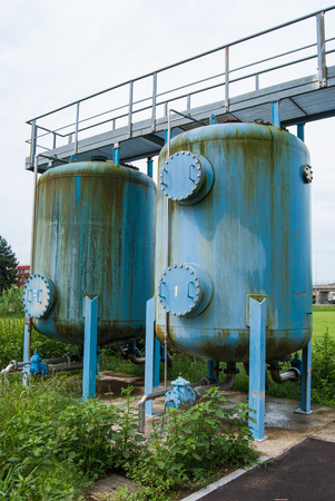 Two water supply tanks with a small metal path over themの写真素材