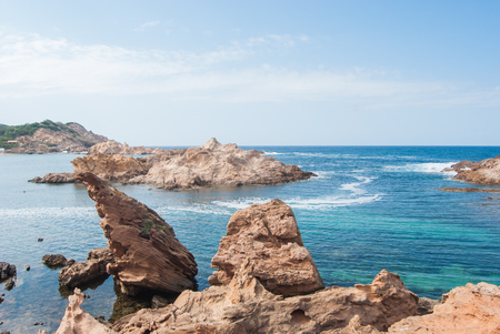 Sand beach and red rocks with contrasting Caribbean seaの写真素材