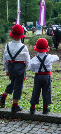 Couple of brothers dressed with red hats white shirt and gray dungareesの写真素材