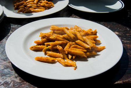 Dish of penne with tomatoes and aubergineの写真素材