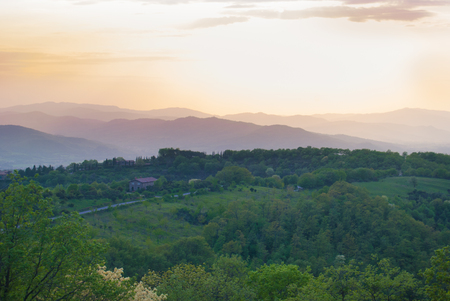 Landscape on farmland among hills in fading during sunsetの写真素材