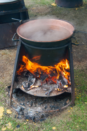 Copper cauldron on the living flame an old method of cooking polentaの写真素材