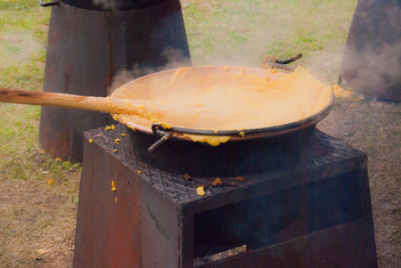 Copper cauldron with polenta on the flame point with a wooden ladleの写真素材