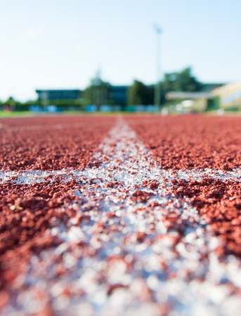 Single white line on the red carpet of the athletics ringの写真素材