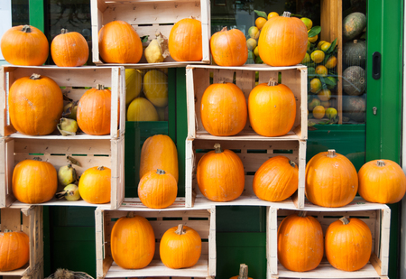 Creative exposition of wooden boxes with many orange pumpkins outside of a greengrocerの写真素材