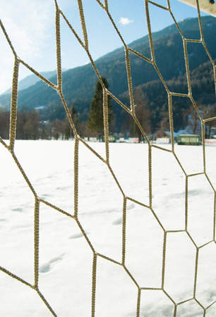 Part of football goal net and snow on the groundの写真素材