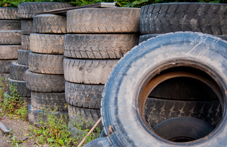 Worn wheels stacked in a tire shopの写真素材