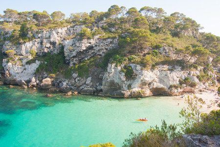 Two adults paddling with a baby on the canoe in one of the most famous beaches of the Spanish islandsの写真素材
