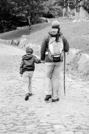 Family walking on a little climb rocky in the mountainの写真素材