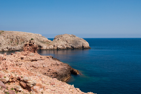 Rocky promontory with reddish earth in the Morell cove areaの写真素材
