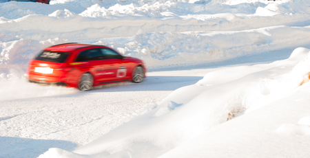 Car in movement on a snowy automotive circuitの写真素材
