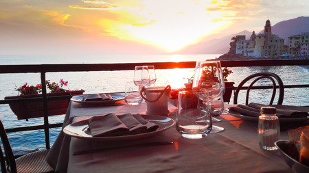 Set table with suggestive sundown on Camogli cityの写真素材