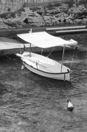 White boat anchored at the buoy in the portの写真素材