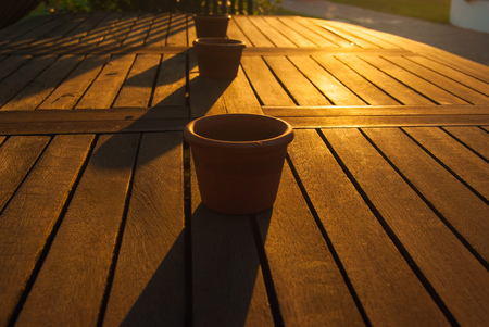 A table illuminated by the rays of the sunset with a ceramics bowlsの写真素材