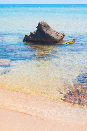 Rock surfacing from the crystalline sea with line of horizonの写真素材