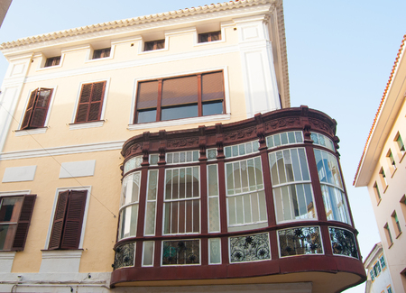 Particular house with curved and covered balcony in the capital of the island of Menorcaのeditorial素材