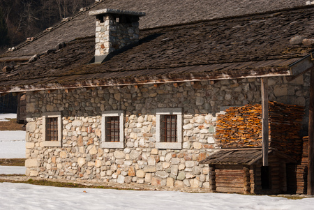 Characteristic stone house with wooden pieces for the stove and little house for dogのeditorial素材
